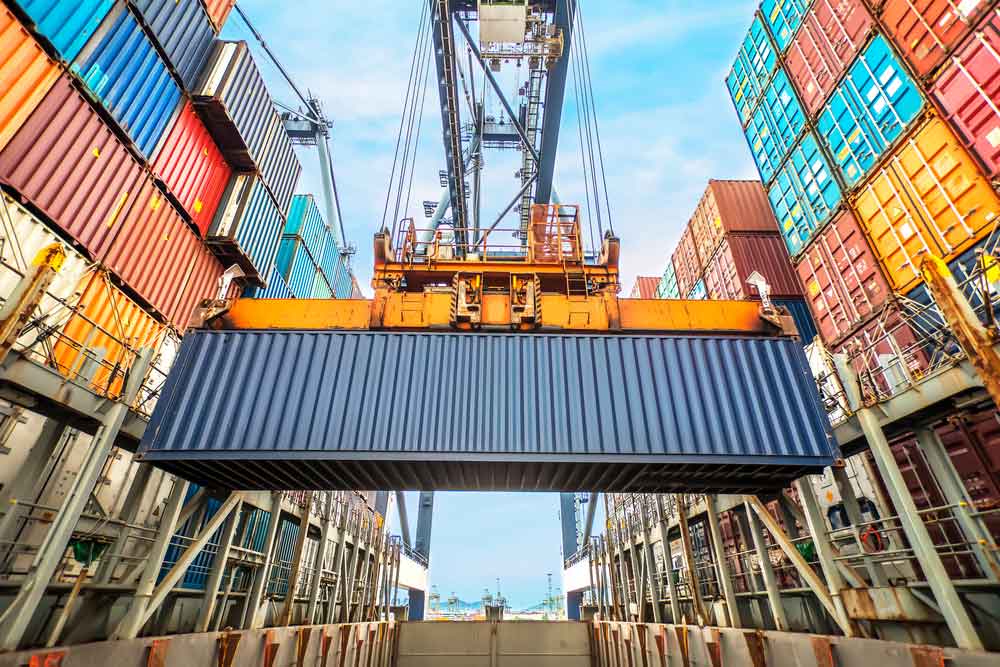 full container being loaded onto ocean transport vessel